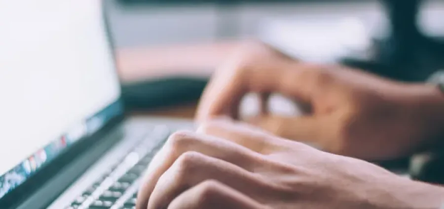 Fingre der skriver på en bærbar computer tastatur